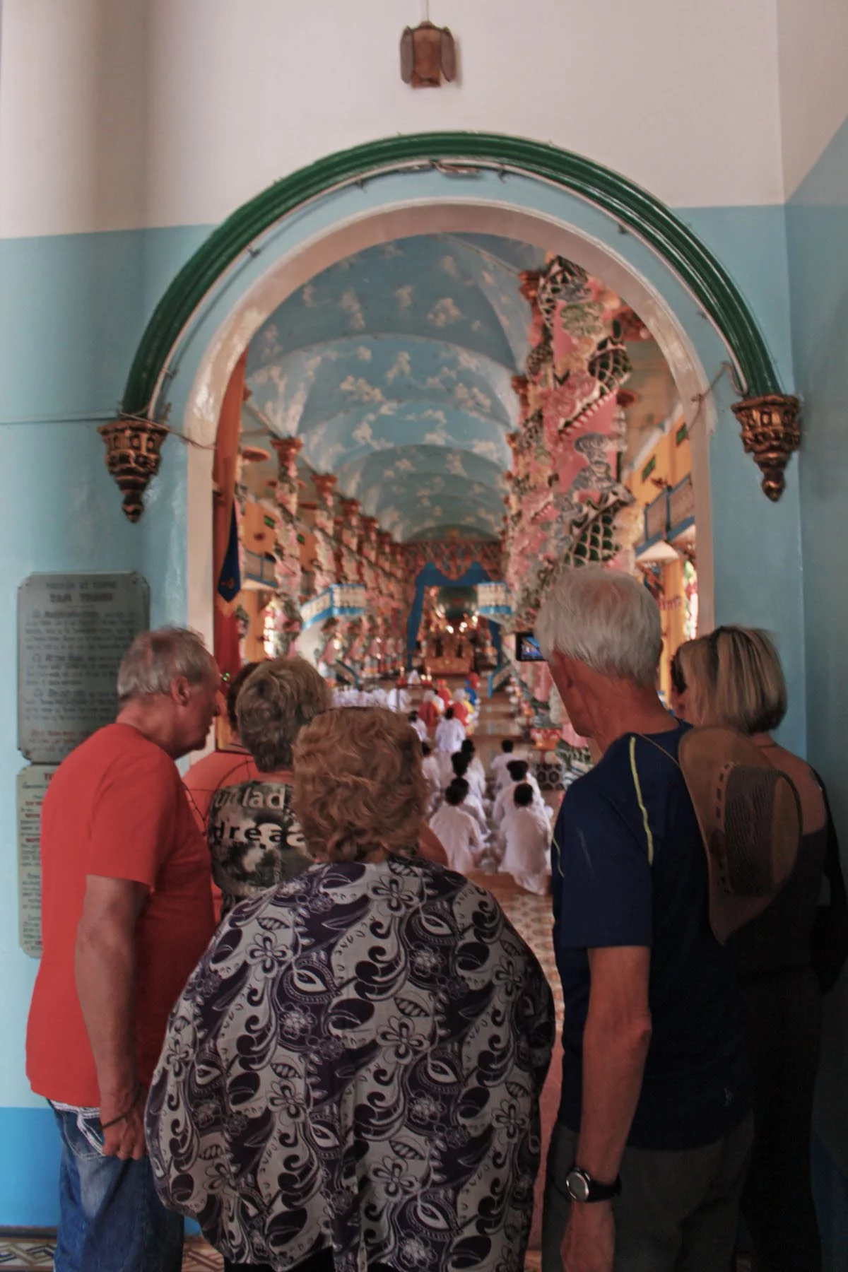 tourists at cao dai temple watching prayers